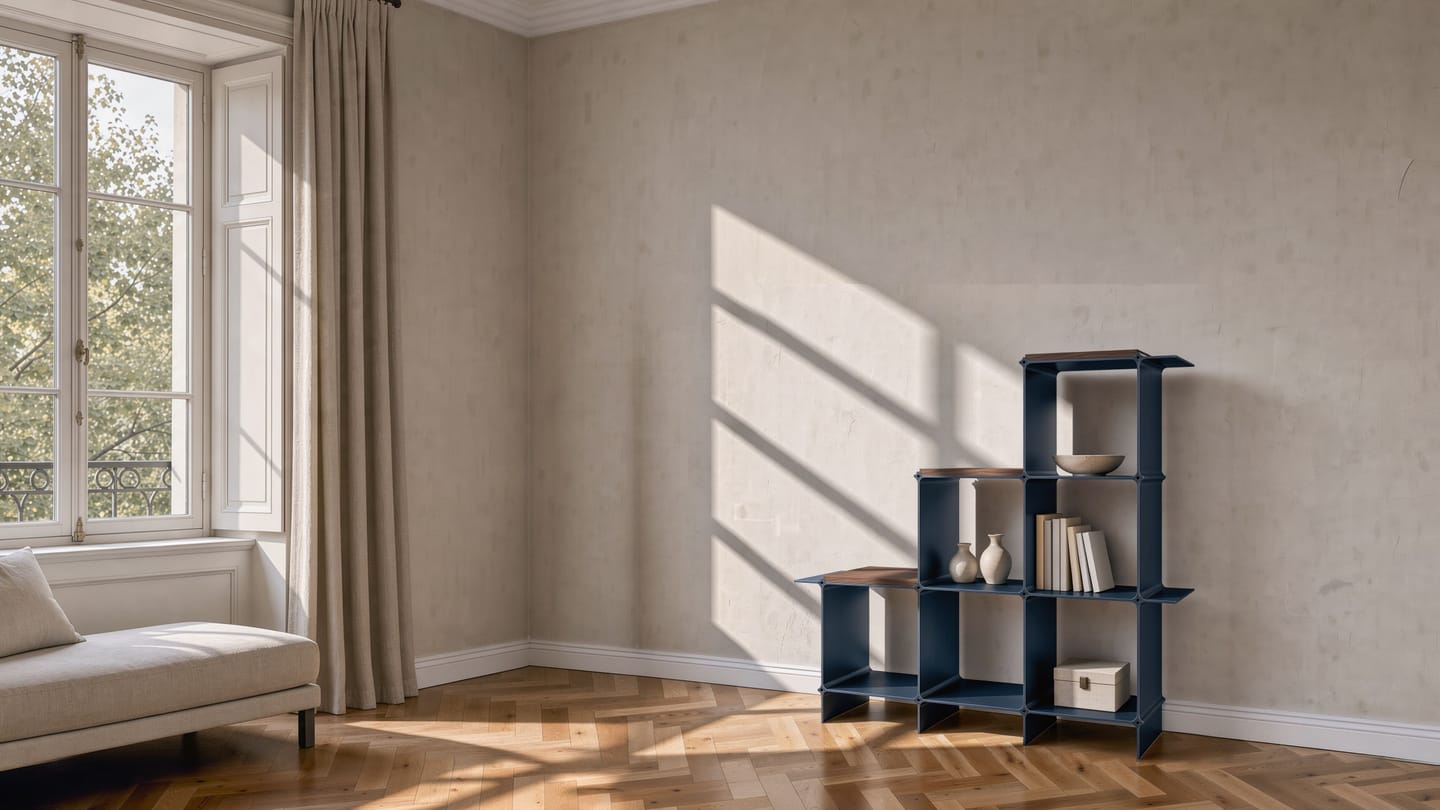 Montique shelving system in dark blue as a staircase of three steps, each with a wooden shelf in walnut — in a period flat beside the tall window, a daybed in front