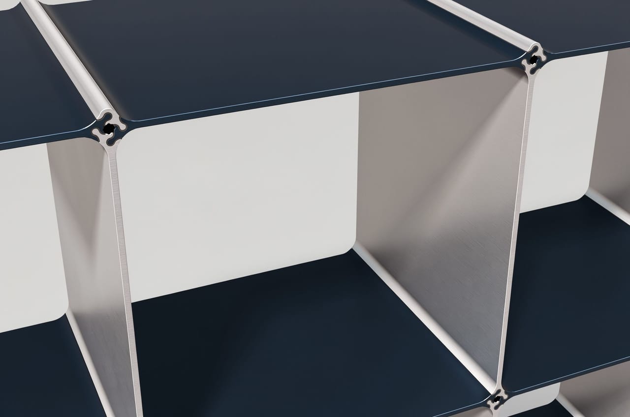 The node up close: four profile ends meet around one hole — side panels in silver, shelves in dark blue