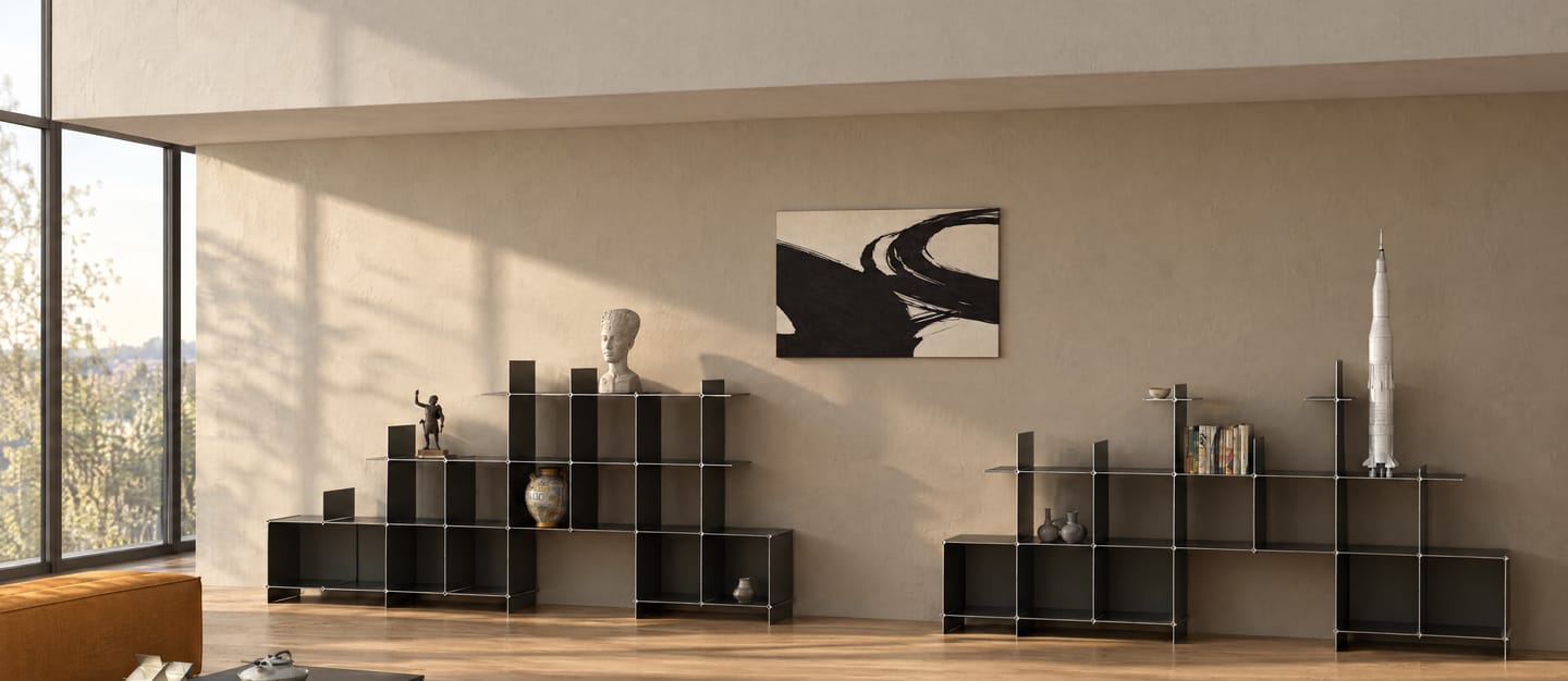 Zwei Montique Regale in Schwarz, gestuft, mit Büste, Vase und Raketenmodell — in einem hellen Loft mit Eichendielen und hohen Fenstern, in der Abendsonne