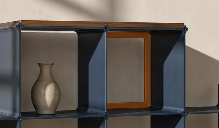 Ablagen in Nussbaum und Rahmen in Orange an einem Regal in Dunkelblau
