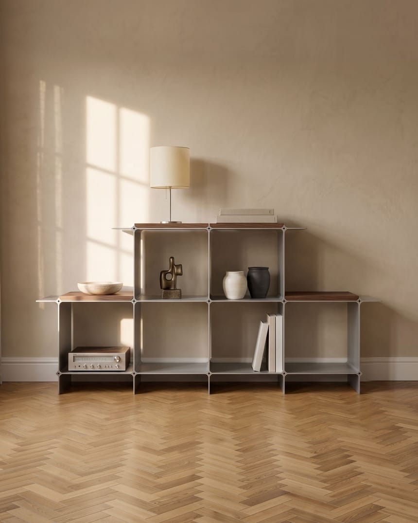 Sideboard 166 — sechs Fächer in Silber, vier Holzablagen in Nussbaum und vier Flügel, darauf eine Tischleuchte; im Altbau, im Licht des Fensters