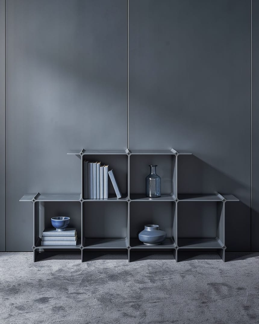 Regal in Dunkelblau mit Büchern und Gefäßen in einem Raum ganz in Blau